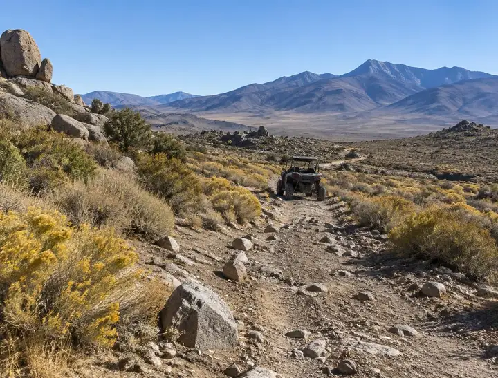 A side-by-side on a rocky high-desert trail, the off-road riding this site covers